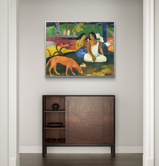 Framed artwork of two women with a dog on a wall above a wooden cabinet.