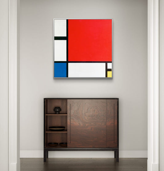 Abstract art piece with primary colors on a wall above a wooden cabinet.