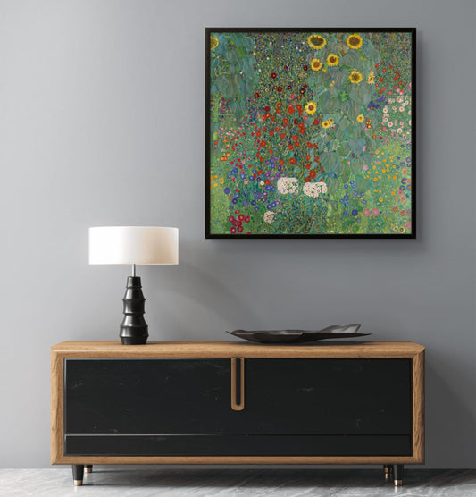 Framed artwork of a floral scene above a wooden cabinet with a lamp and decorative plate.