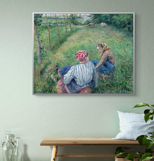 Framed painting of two women in a field on a wall above a wooden bench.