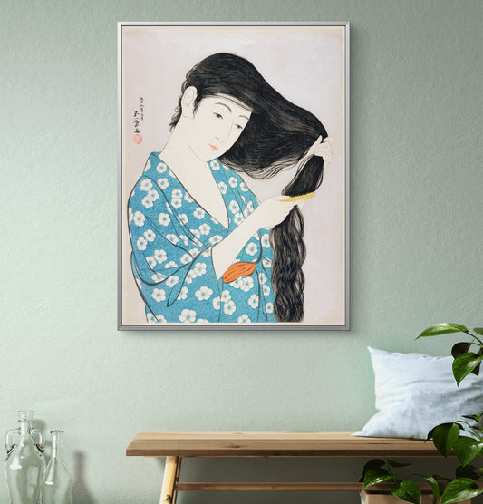 Framed artwork of a woman in a floral kimono against a light green wall.