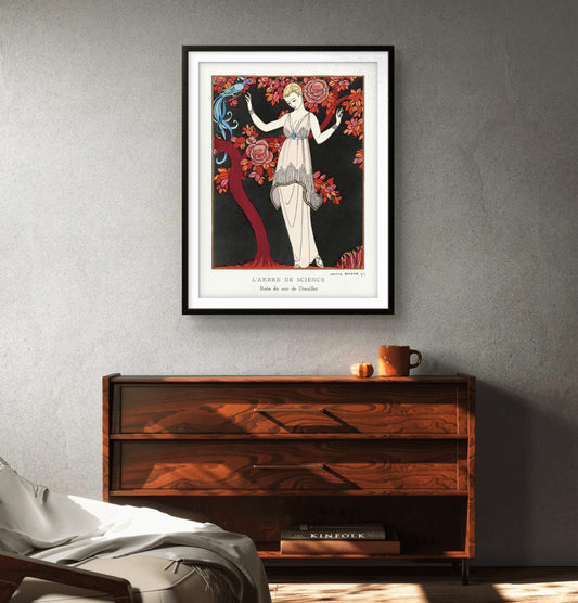 Framed art print of a woman in a dress on a gray wall above a wooden cabinet.