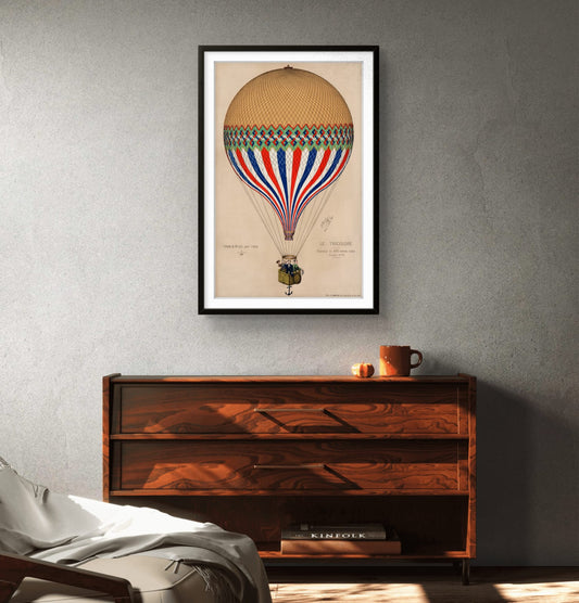 Framed artwork of a hot air balloon on a wall above a wooden console table.