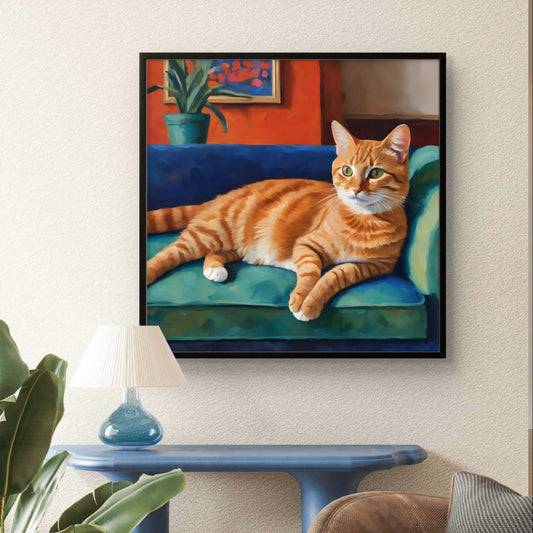 A colorful painting of a lounging orange cat on a blue cushion, displayed on a wall above a blue table in a room with a gray sofa and a potted plant.
