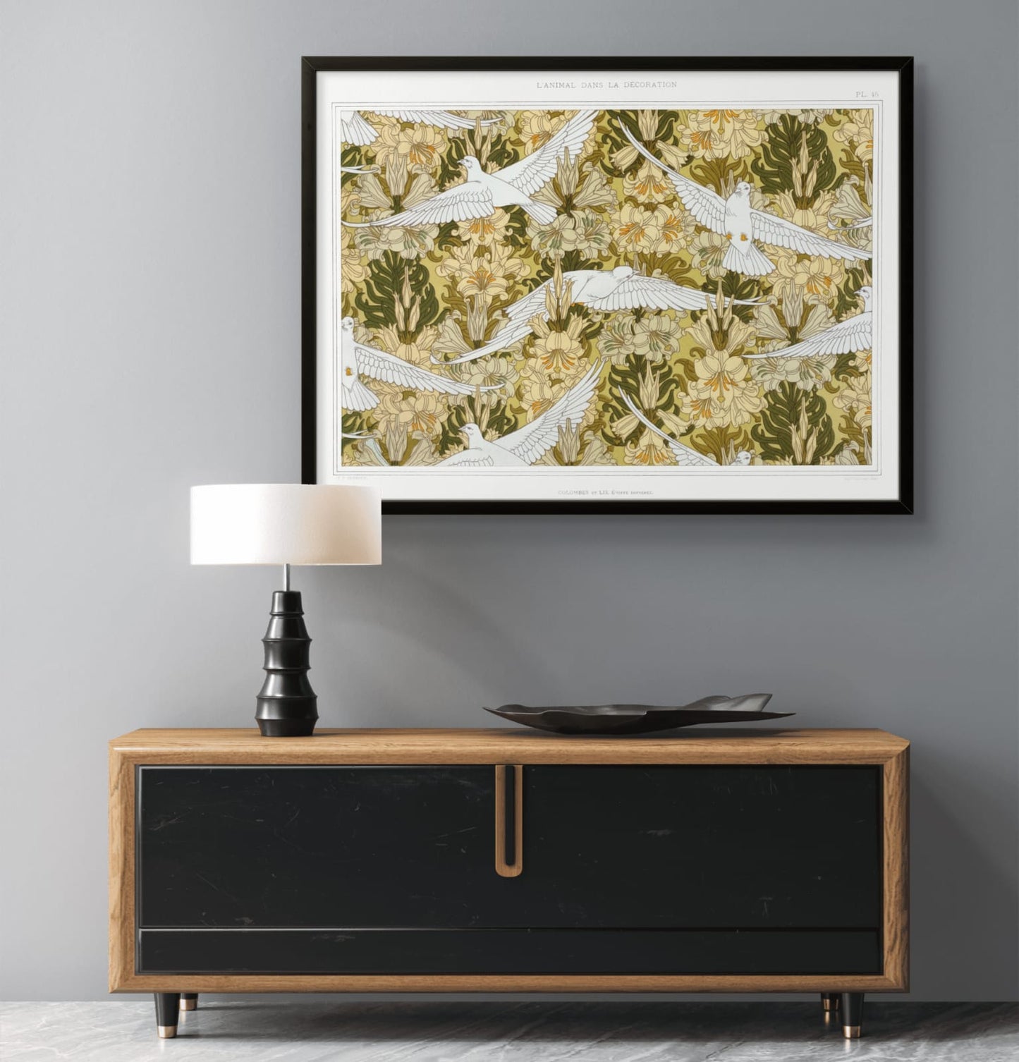 Framed artwork above a wooden console table with a lamp and decorative plate.