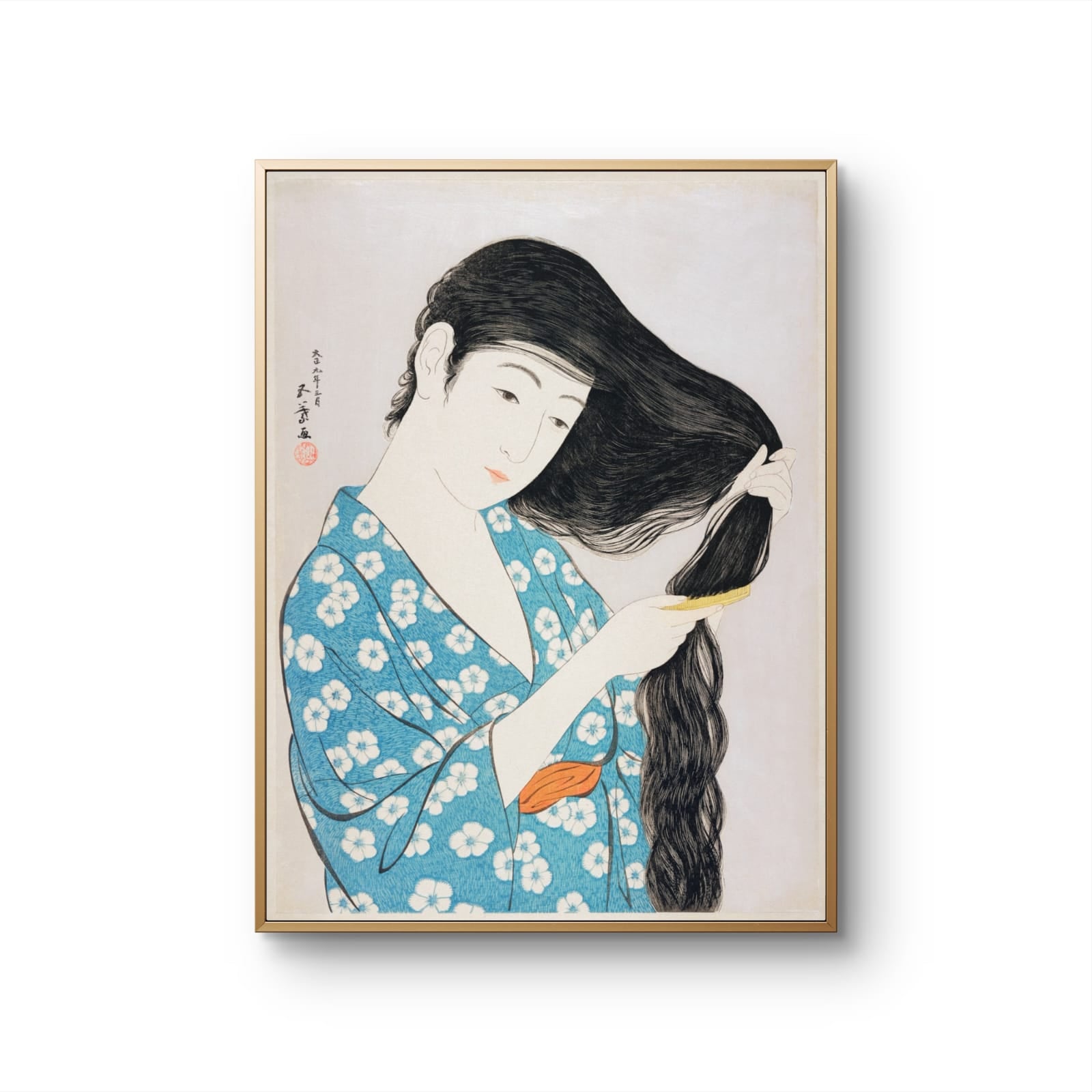 Framed artwork of a woman in a blue kimono with white flowers, combing her hair.
