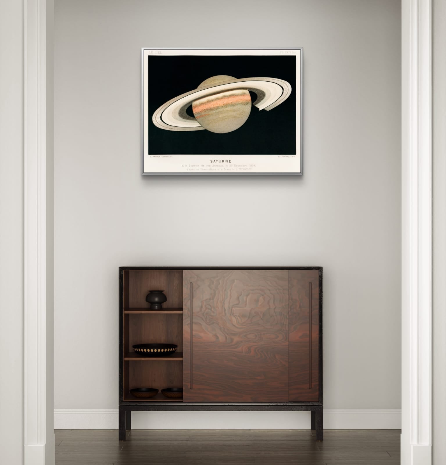 Framed artwork of Saturn on a wall above a wooden cabinet.
