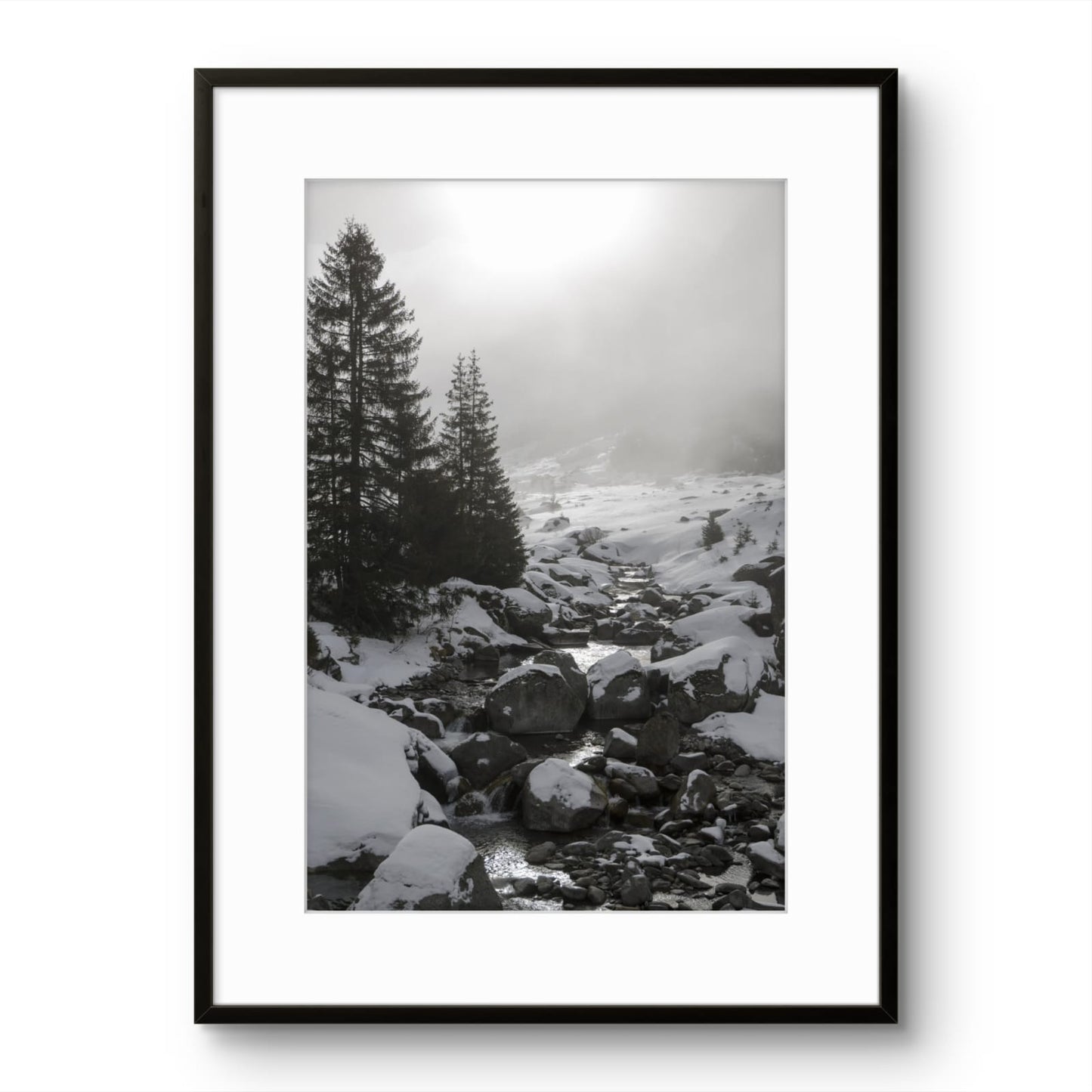 Framed black and white photograph of a snowy landscape with trees and rocks.