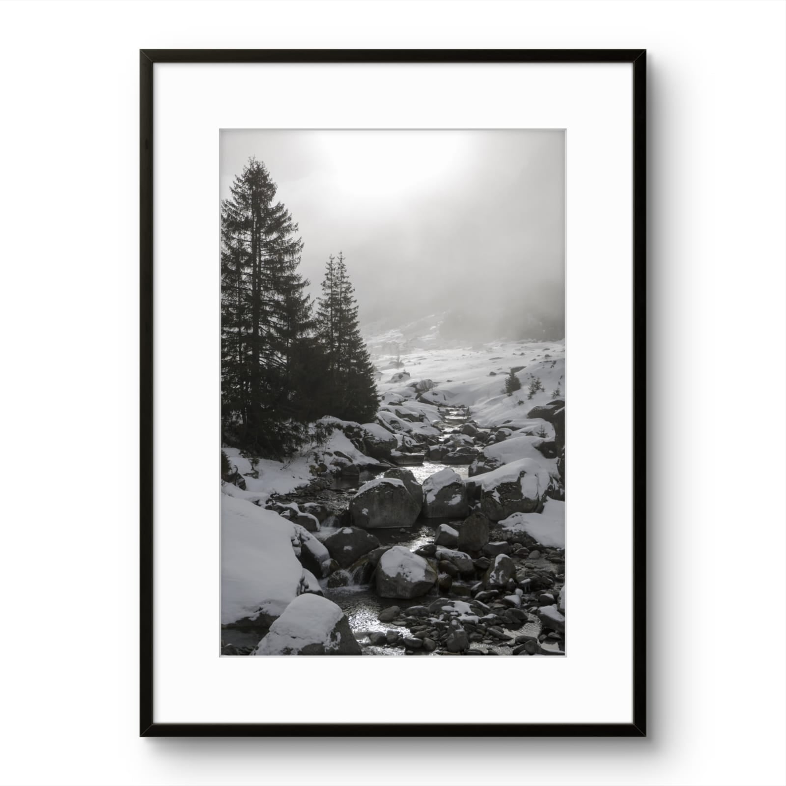 Framed black and white photograph of a snowy landscape with trees and rocks.