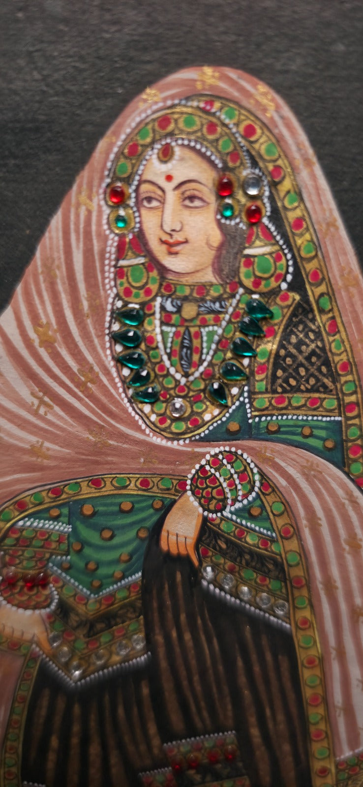 Decorative portrait of a woman with intricate jewelry and clothing on a dark background