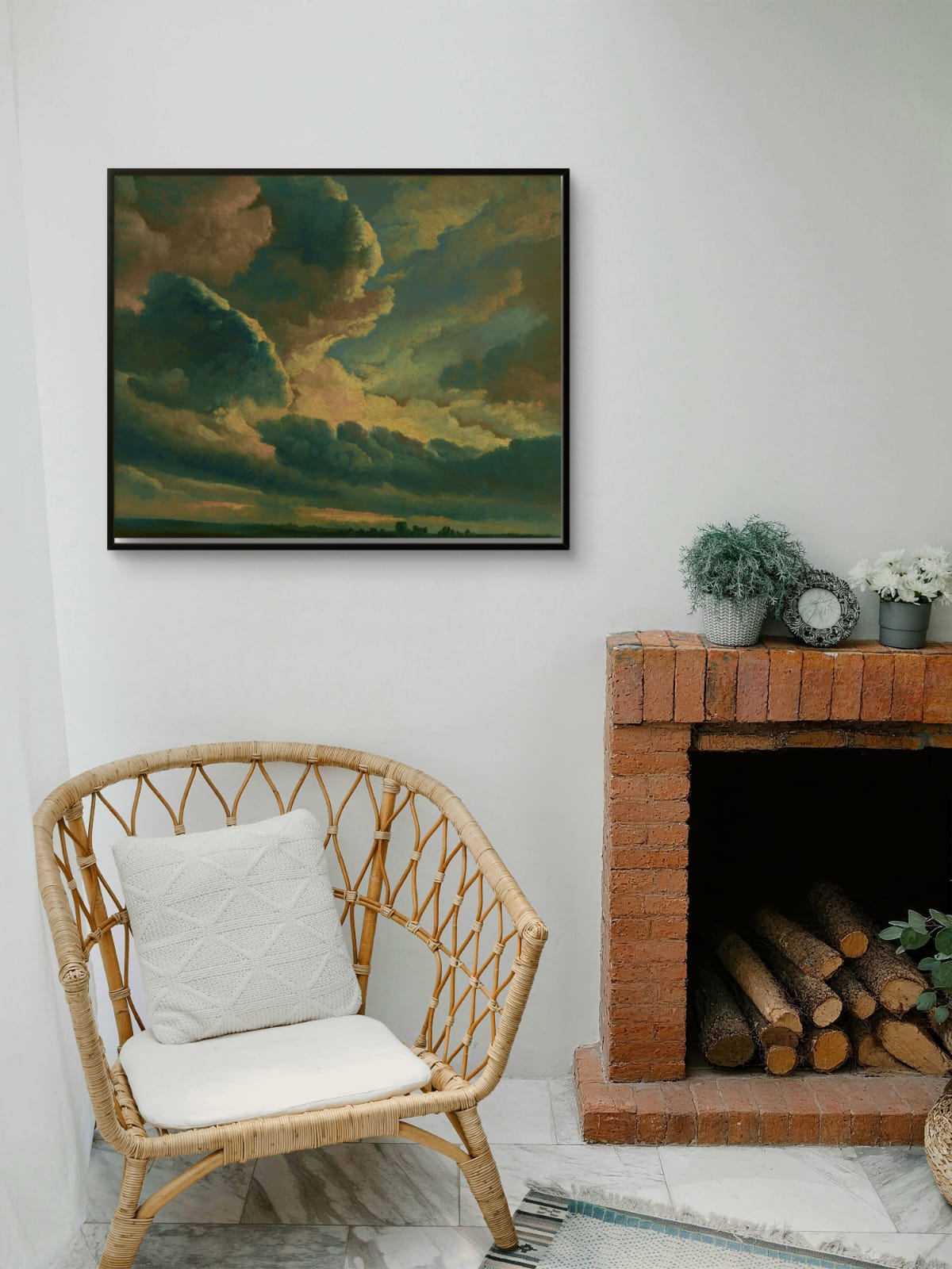 Living room with a wicker chair, fireplace, and framed artwork of a sunset.